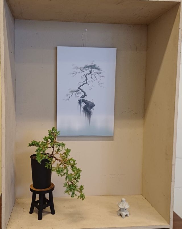 Tokonoma met een jeneverbes in halfcascade op een zwart krukje, een schilderij van een boom en een klein stenen lantaarntje.